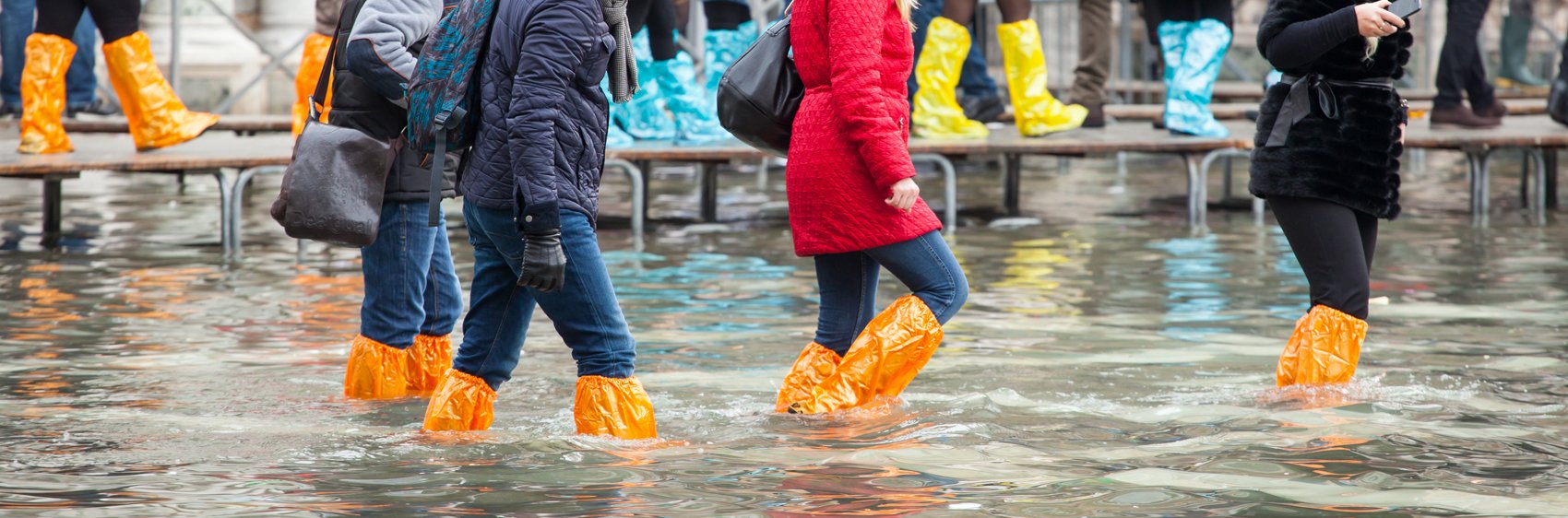 Personnes marchant n bottes en caoutchouc dans les rues inondées