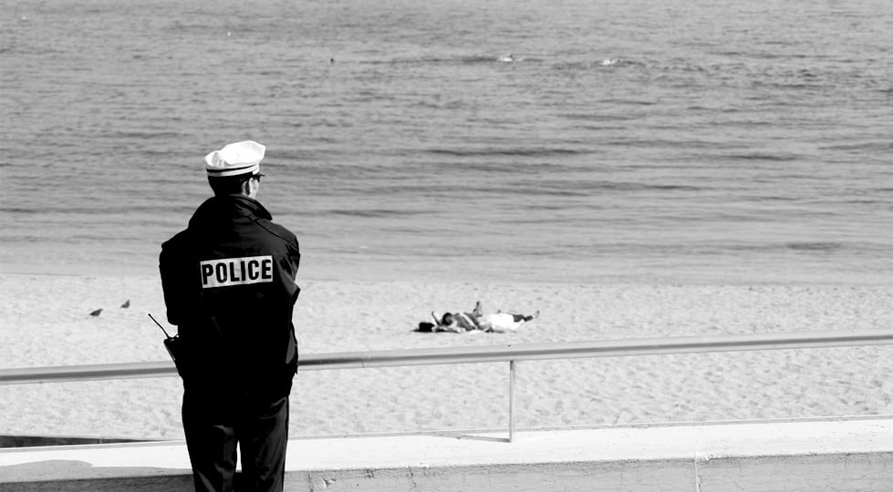 (image) policier de dos regardant la mer